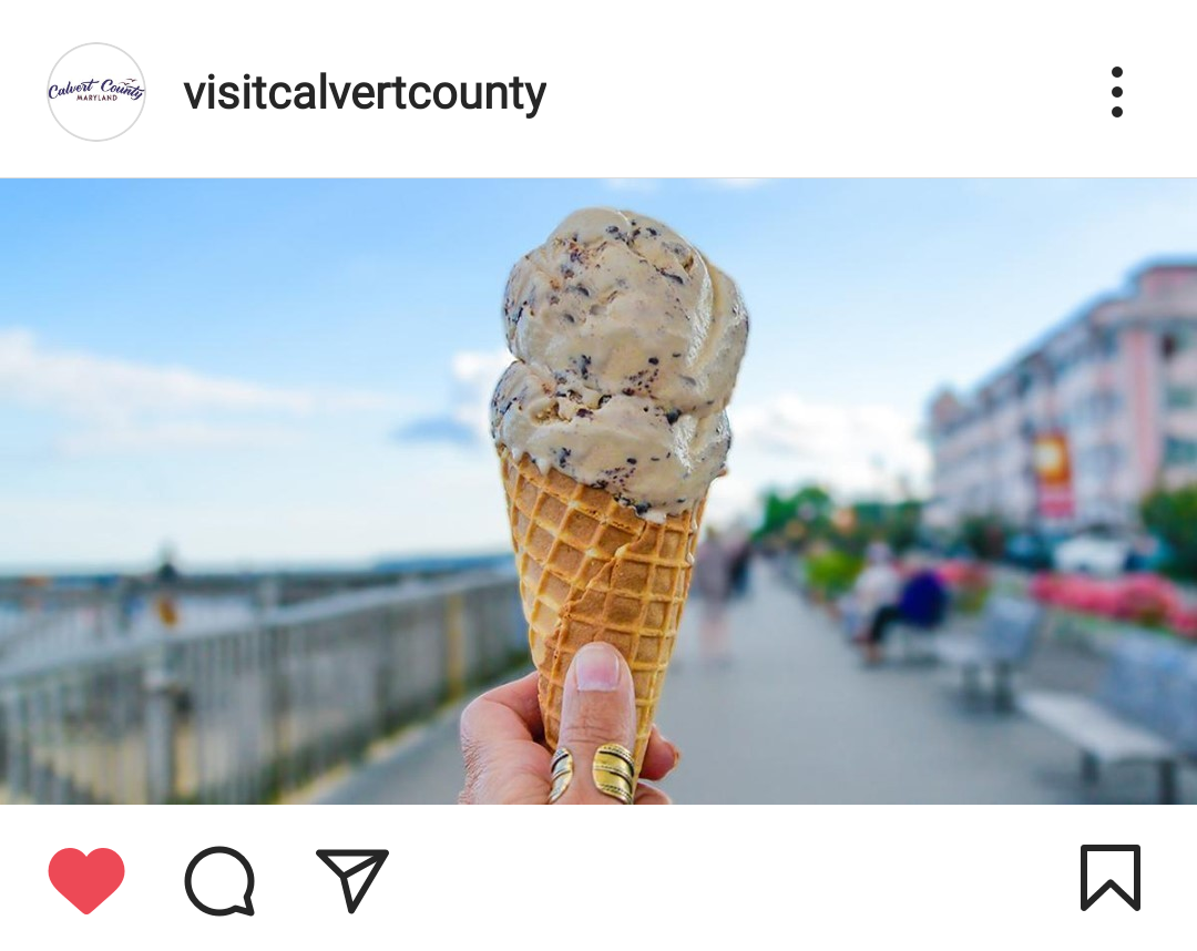 Instagram screenshot of an ice cream cone held up in front of the North Beach boardwalk
