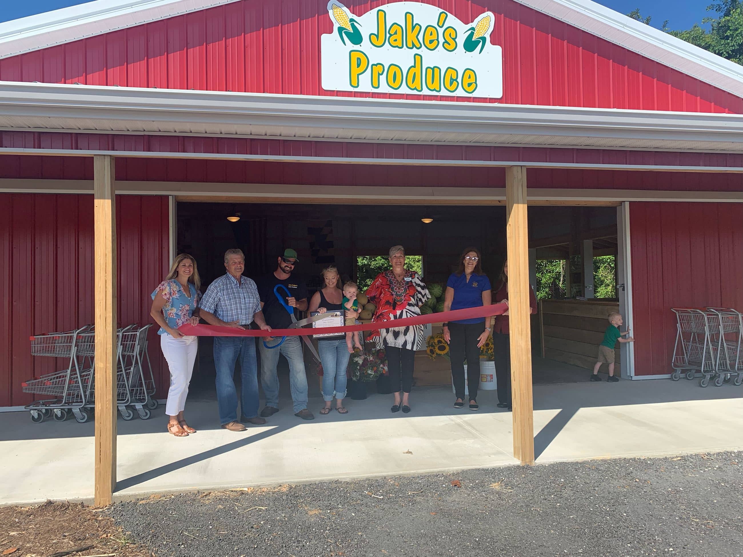 Group holding large ceremonial scissors for ribbon cutting event 