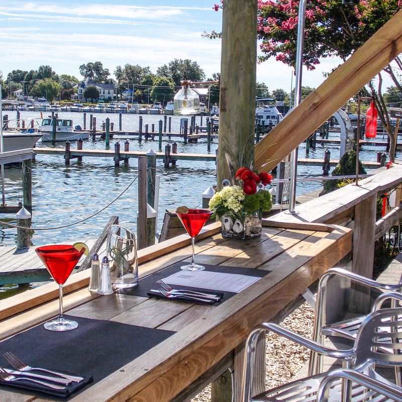 Seating overlooking the water with a menu and martini glass