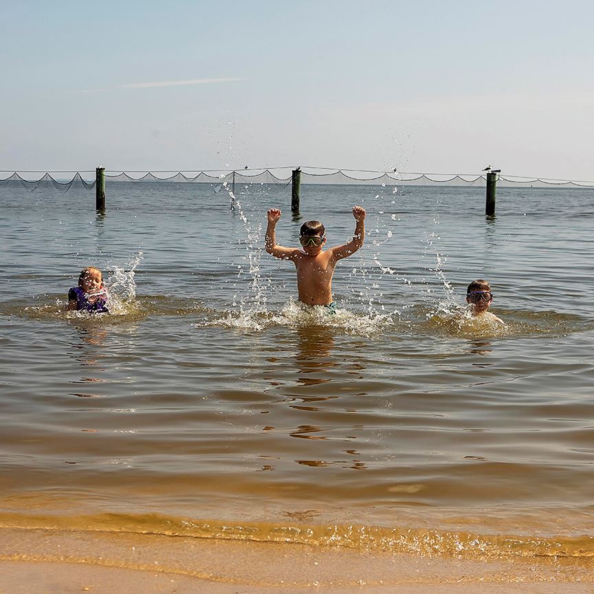 Three children jumping in the water